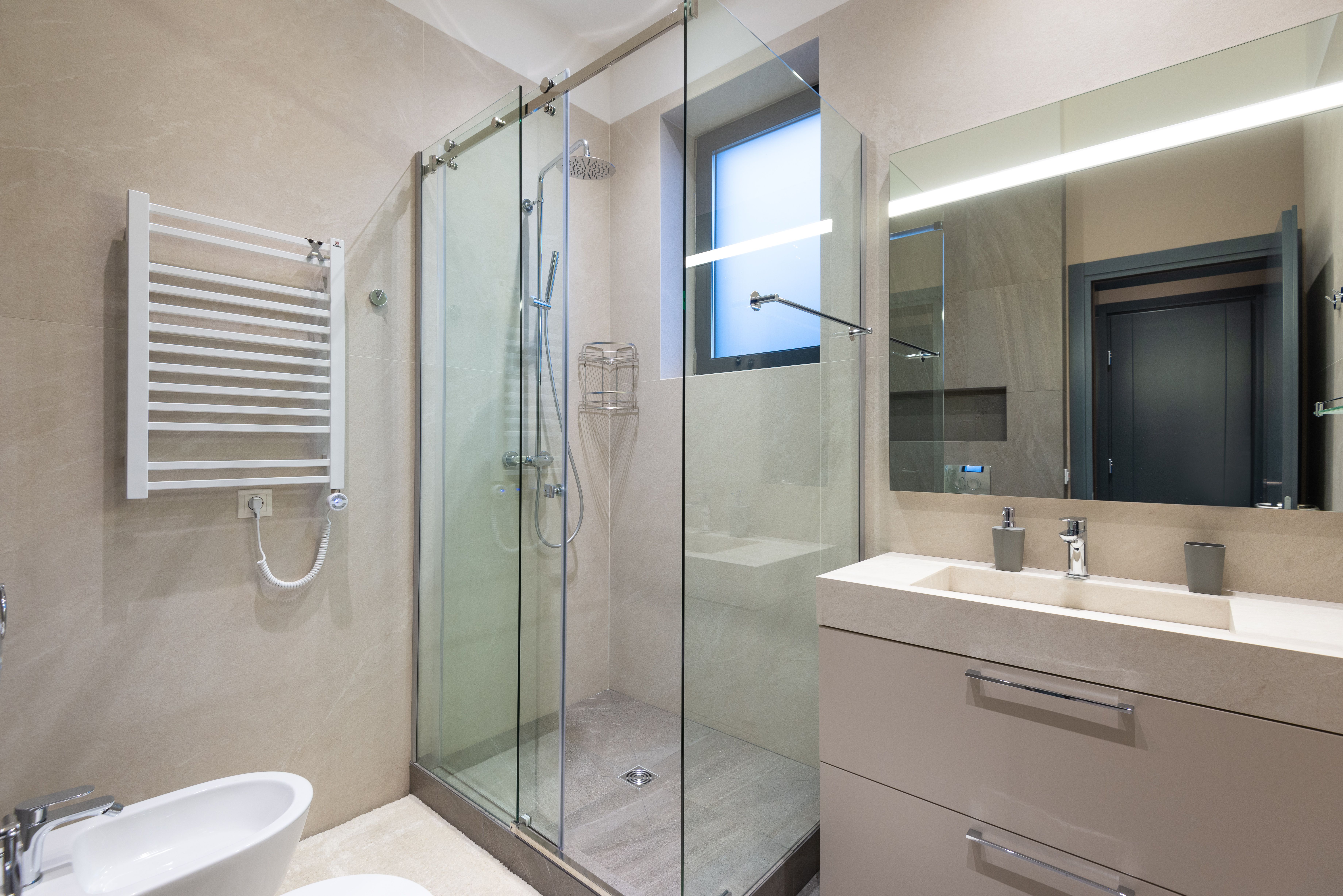 Modern bathroom featuring upgrades like a towel warmer on the far wall